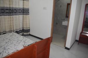 - une chambre avec un lit, une douche et un miroir dans l'établissement Shenu Resort, à Mawella