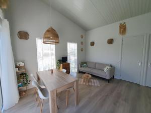 a living room with a table and a couch at Have a nice stay! - Vakantiehuis Buitenplaats in Noordwijkerhout