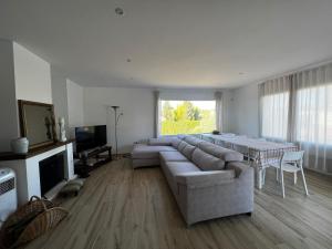 ein Wohnzimmer mit einem großen Sofa und einem Tisch in der Unterkunft Acogedora casa con piscina in Lliria