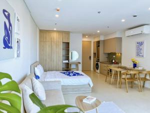 a bedroom with a bed and a table and a kitchen at The Sóng Vũng Tàu - Mai Hà Homestay in Vung Tau