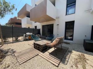 a patio with a table and chairs and a building at Lady Lafé Kaz Appartement in Frontignan