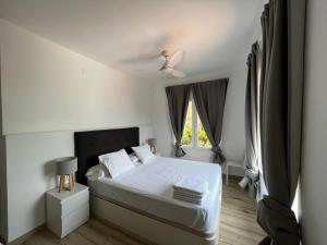 ein weißes Schlafzimmer mit einem Bett und einem Fenster in der Unterkunft Acogedora casa con piscina in Lliria