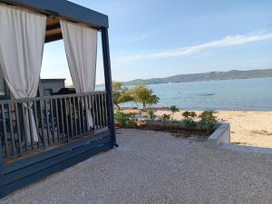una casa con balcón con vista al agua en Mobilna kućica Mimi, en Sveti Petar