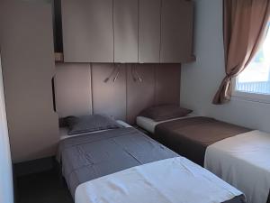 Habitación con 2 camas, armario y ventana en Mobilna kućica Mimi, en Sveti Petar