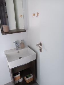 Un baño con un lavabo blanco y un espejo. en Mobilna kućica Mimi, en Sveti Petar