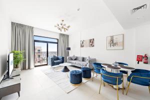 a living room with a couch and a table and chairs at A Living One 1BR Apartment At Asayel 3, Madinat Jumeirah in Dubai