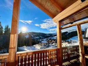a view from the porch of a cabin with snow covered mountains at Sonnberg Chalet - Entspannung pur im Luxus Chalet mit Whirlpool-Sauna in Lachtal