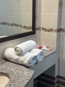 a bathroom with towels on a counter and a mirror at Hotel de Papae in Islamabad