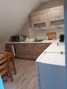 a kitchen with a white refrigerator and wooden cabinets at Pod Żurawiem in Bóbrka