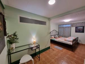 een kamer met een bed en een tafel in een kamer bij Kanlayana Hostel in Ban Bang Toei (1)