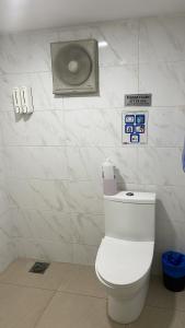 a bathroom with a toilet with signs on the wall at J Capsule Hotel in Kuala Lumpur