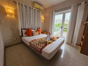 a bedroom with a large bed and a large window at J & P Lodge in Pereybere