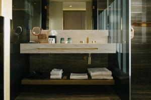 a bathroom with a sink and a shelf with towels at Vila Foz Hotel & SPA - member of Design Hotels in Porto