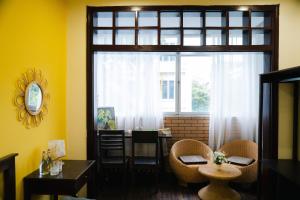 ein Esszimmer mit einem Tisch und einem großen Fenster in der Unterkunft Rêver Home in Hanoi