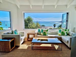 Una sala de estar con vista al mar. en Cosy Beach Bungalow On Clifton, en Ciudad del Cabo