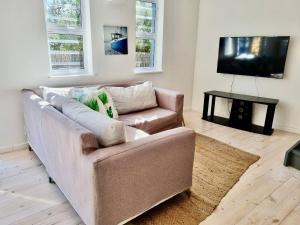 Una sala de estar con un sofá y un televisor de pantalla plana. en Cosy Beach Bungalow On Clifton, en Ciudad del Cabo