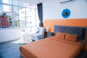 ein Schlafzimmer mit einem Bett und einem Stuhl und einem Fenster in der Unterkunft Rêver Home in Hanoi