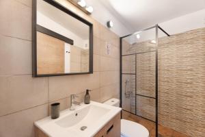 a bathroom with a sink and a mirror and a toilet at Vivienda vacacional La Era I in Vallehermoso