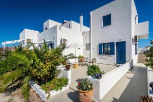 ein weißes Haus mit Pflanzen davor in der Unterkunft Firiki Studios in Zefiría