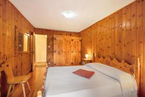 a bedroom with wooden walls and a bed and a chair at Maison Marcel Sarre in Aosta