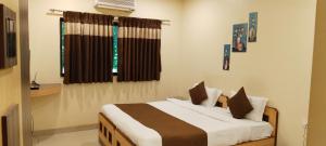 a bedroom with a bed and a window at Aquarius Resort in Pune +10 photos