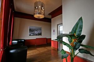 a living room with a chandelier and a plant at York House Hotel in Wakefield