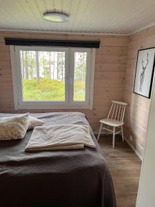 a bedroom with a bed and a chair and a window at Kalliorinne in Ruka +9 photos