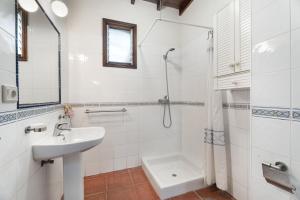 a white bathroom with a sink and a shower at Casa Afortunada in Hermigua +20 photos