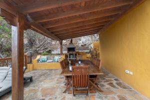 a wooden table and chairs on a patio at Casa Afortunada in Hermigua