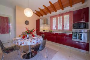 Villa Clara few km from the sea - Happy Rentals في بيتراسانتا: مطبخ مع طاولة عليها زهور