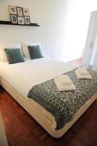 un grande letto bianco con due cuscini sopra di Porto City Center Mercado do Bolhão Prime location jesuína e as 3 janelas a Porto
