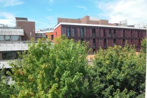 un edificio rosso con alberi di fronte di Porto City Center Mercado do Bolhão Prime location jesuína e as 3 janelas a Porto Altre 100 foto