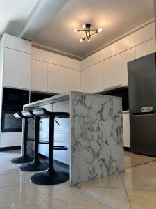 a kitchen with two bar stools and a counter at Villa Castle View in Shkodër