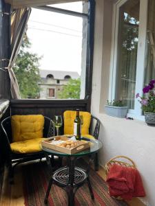 a table and chairs on a porch with a window at Apartment Gabliani in Mestia