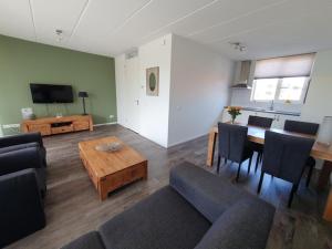 a living room with a couch and a table and a television at 'n Ice Day 3A in Zoutelande