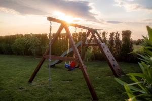 a swing set in a field with the sunset at Villa Moonlight 1 near Poreč for 9 person - pet friendly with large garden, playground & 50 m2 pool in Višnjan