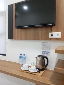 a kitchen counter with a microwave and a tea kettle at Hotel Bhakti Syariah in Padang