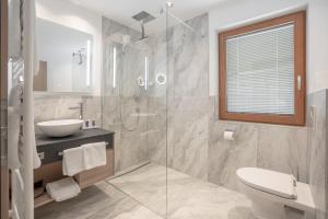 ein Badezimmer mit Dusche, Waschbecken und Toilette in der Unterkunft Chalet Madlein in Ischgl