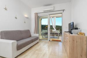 a living room with a couch and a sliding glass door at Villa Smeraldina in Olbia
