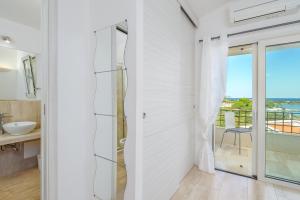 a bathroom with a sliding glass door with a view of the ocean at Villa Smeraldina in Olbia +16 photos