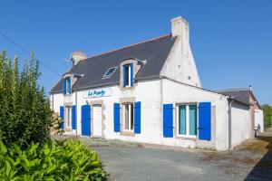 an old white building with blue shutters at Maison familiale 800m de la plage in Penmarcʼh
