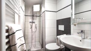 a bathroom with a toilet and a sink at MARKTWIRTSCHAFT Restaurant & Hotel in Freudenstadt +8 photos