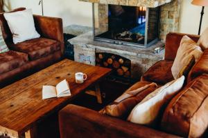 a living room with couches and a coffee table and a fireplace at Le Cochet by Lodji in Saint-Martin-de-Belleville +21 photos