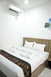 Postel nebo postele na pokoji v ubytování Hotel Bhakti Syariah