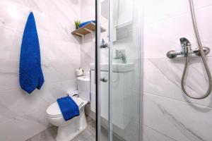 a bathroom with a toilet and a shower with blue towels at El Golfito-azotea con vista al mar in El Golfo +15 photos