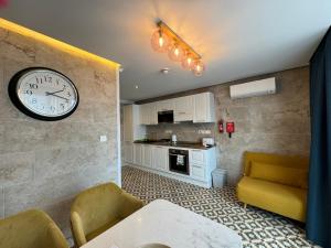 ein Wohnzimmer mit einer Uhr an der Wand in der Unterkunft Balcony Studios in St Julian's