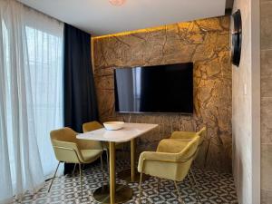 ein Zimmer mit Tisch, Stühlen und Fernseher in der Unterkunft Balcony Studios in St Julian's