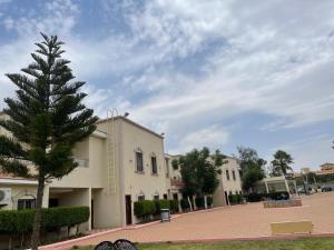 Al Muhaidb Residence for Chalets and Holidays Homes المهيدب ريزدنس لبيوت العطلات في الهدا: مبنى به شجرة في منتصف الشارع
