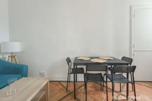 a black table and chairs in a living room at Flexliving - room - Lemoine in Paris