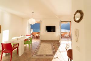 ColonnoにあるSplendida casa con terrazza vista lago e 2 garageのテーブルと椅子のあるリビングルームとダイニングルーム